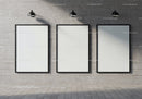 Minimalist blank frames on concrete wall with spotlights