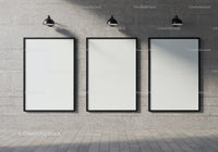 Minimalist blank frames on concrete wall with spotlights