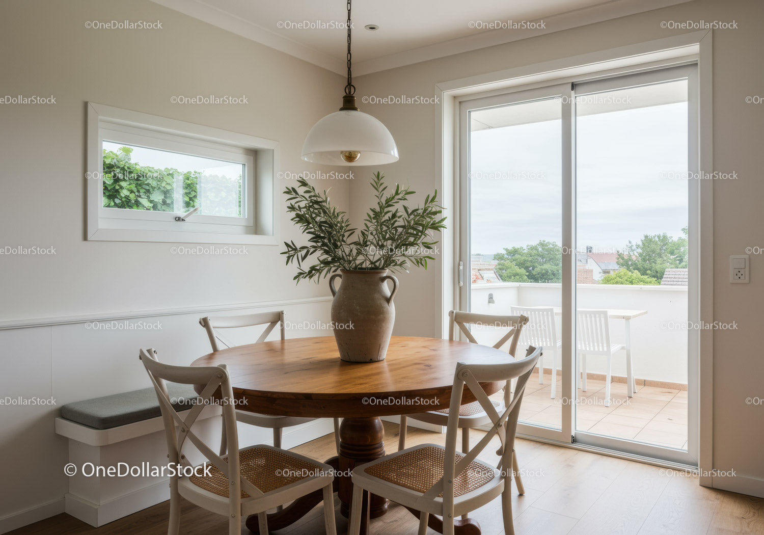 Cozy dining area with round wooden table and greenery