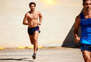 Two men running outdoors on sunny day in sportswear