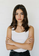 Young Woman with Confident Expression and Crossed Arms in Studio