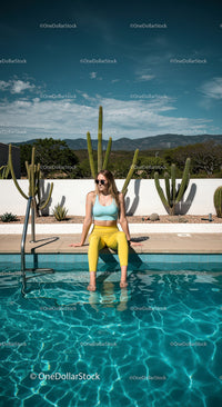 Trendy Young Woman Relaxing by the Vibrant Swimming Pool