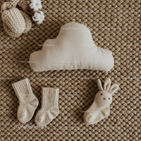 Neutral toned baby essentials on woven textured rug