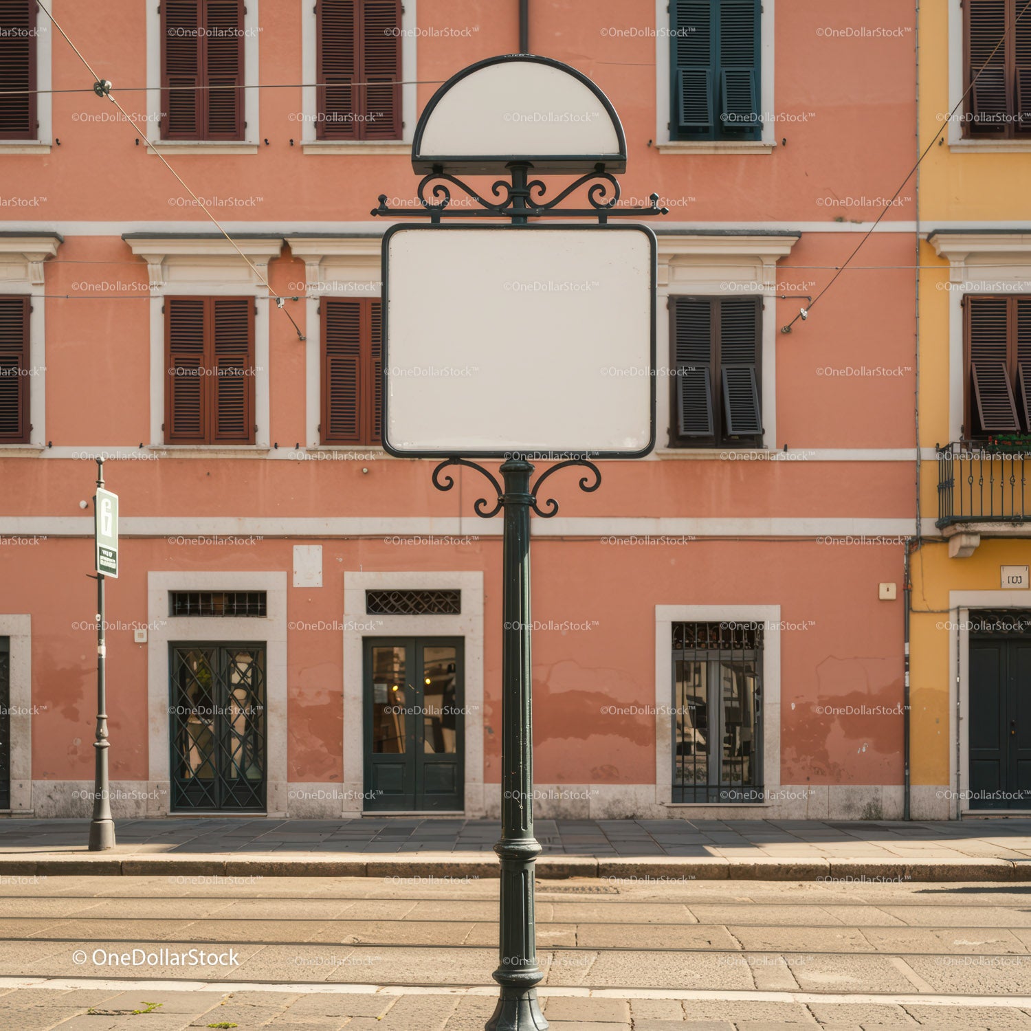 Pusty, zabytkowy znak drogowy przed fasadą pastelowego budynku