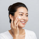 Young Woman Applying facial Moisturizer with Healthy Skin Glow