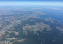 Scenic Aerial View of Forests and Water Bodies Over Rolling Terrain