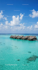 Overwater Bungalows on Tropical Lagoon with Clear Blue Water and Sky