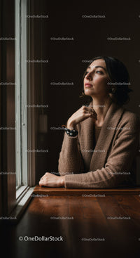 Elegant Woman Sitting by a Window with Natural Light