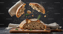 Rustic Bread Breaking with Flying Crumbs and Herbs