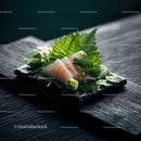 Fresh Sashimi Placed on Black Plate with Green Garnishes and Wasabi