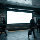 Busy commuters passing empty billboard in subway station
