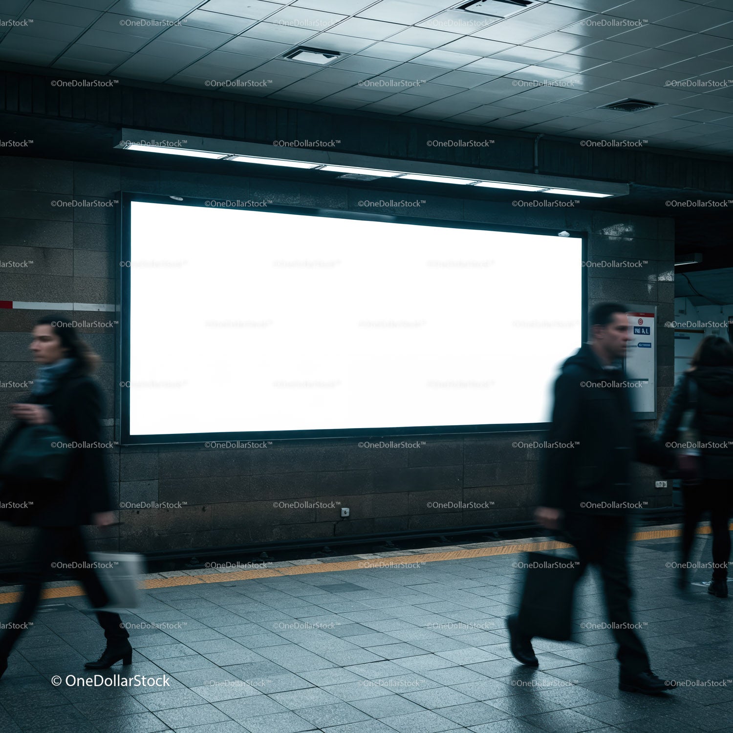 Busy commuters passing empty billboard in subway station