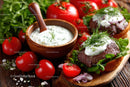 Fresh Cherry Tomatoes and Grilled Beef Steaks with Herb Sauce on Rustic Board