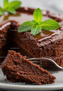 Moist chocolate cake slice with fresh mint garnish