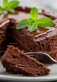 Moist chocolate cake slice with fresh mint garnish