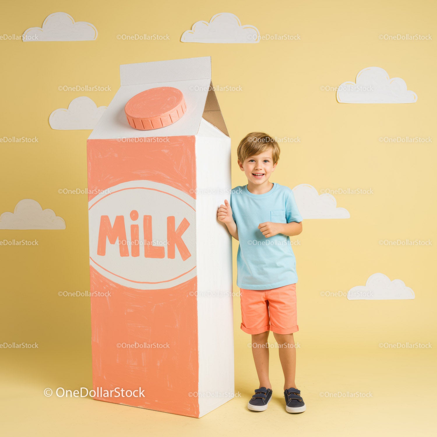 Happy boy standing next to giant milk carton prop