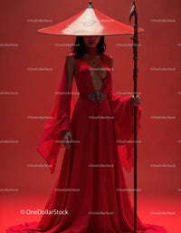 Elegant Woman in Red Dress with Accessories Against Red Background