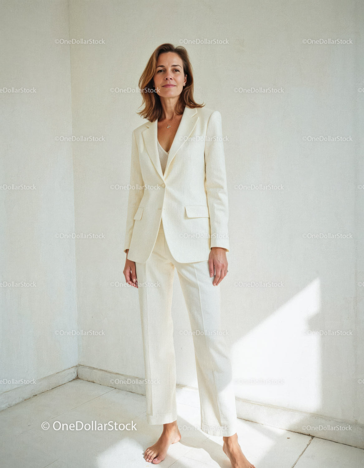 Elegant Woman in Off-White Suit Standing in Minimalist Room