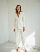 Elegant Woman in Off-White Suit Standing in Minimalist Room