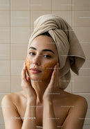 Relaxing Woman Applying Facial Mask with Towels Wrapped Hair
