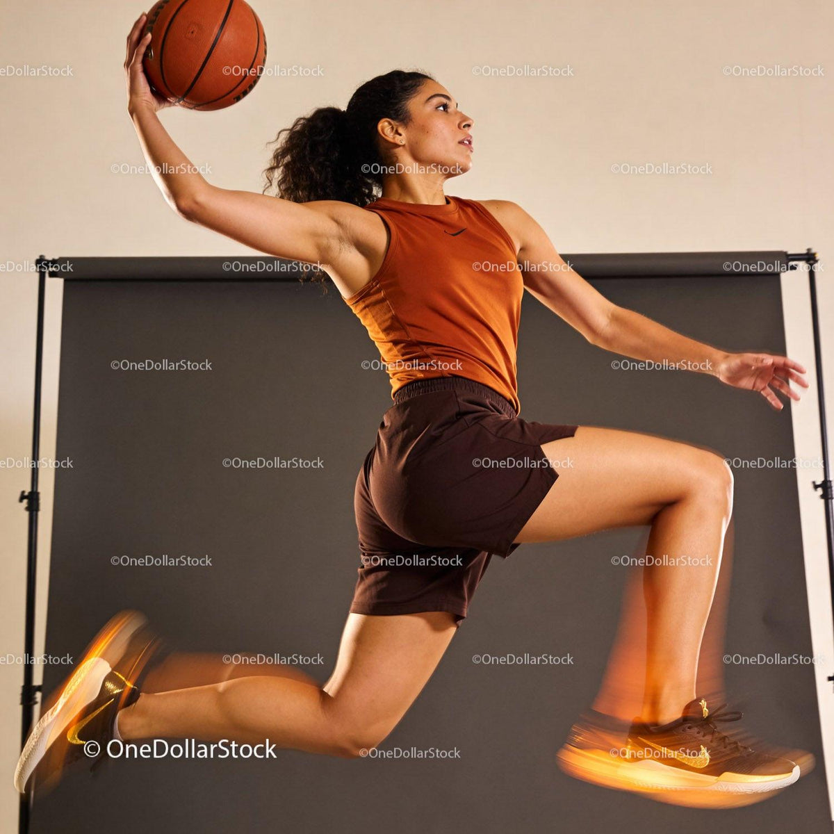 Athletic Woman Leaping for Basketball Dunk in Studio