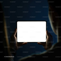 Person Holding Bright Tablet Screen in Dark Room