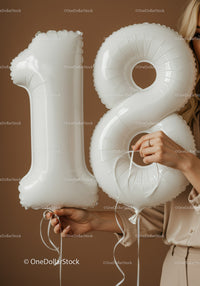 White Number 18 Balloon Held by Woman in Neutral Outfit