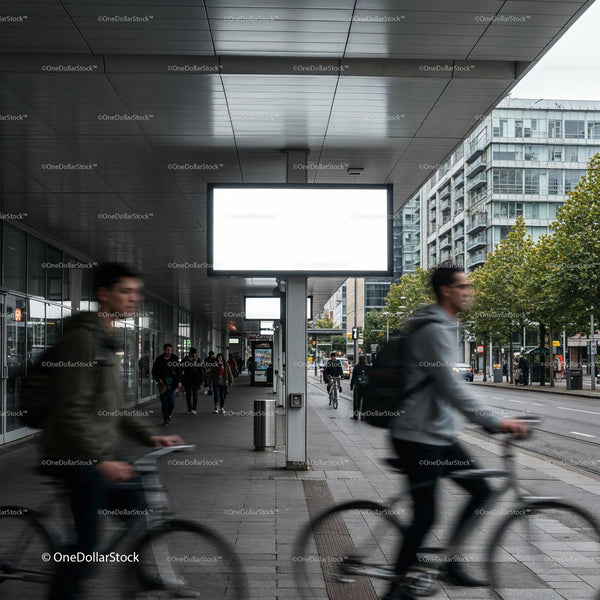 Urban commuters cycling past illuminated blank billboards JPG Mockup Image