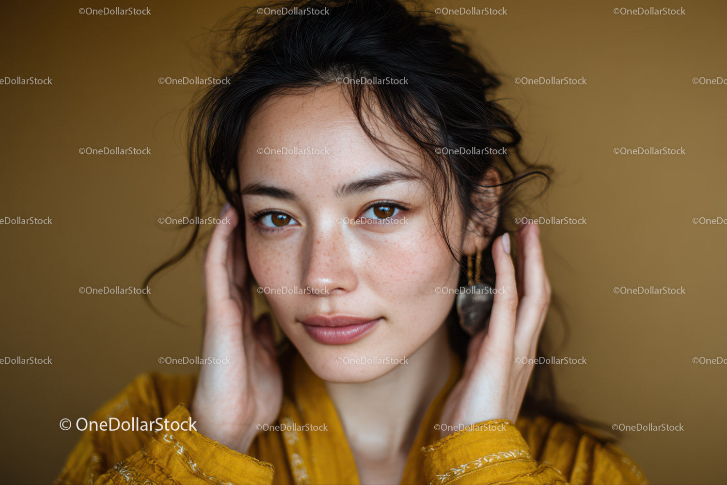 Young woman with dark wavy hair and freckles in yellow clothing