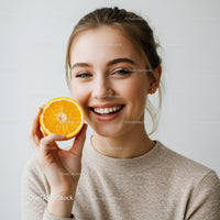 Joyful Woman Holding Fresh Orange with Bright Smile in Casual Setting