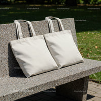 Two Plain Reusable Tote Bags on Outdoor Stone Bench