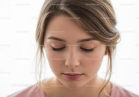 Young Woman with Closed Eyes and Serene Expression in Natural Light