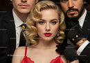 Elegant Blonde Woman in Red Lace Dress Surrounded by Men in Black Suits