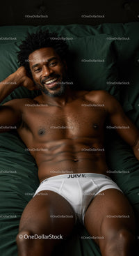 Smiling man relaxing on bed in white underwear
