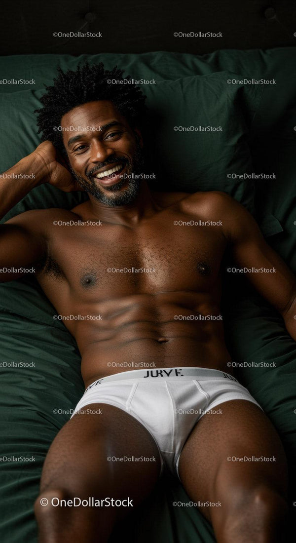 Smiling man relaxing on bed in white underwear