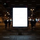 Illuminated blank billboard on urban street at night