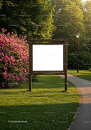 Empty wooden signboard in park with blooming pink flowers