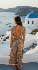 Woman in patterned dress overlooking Santorini sea view
