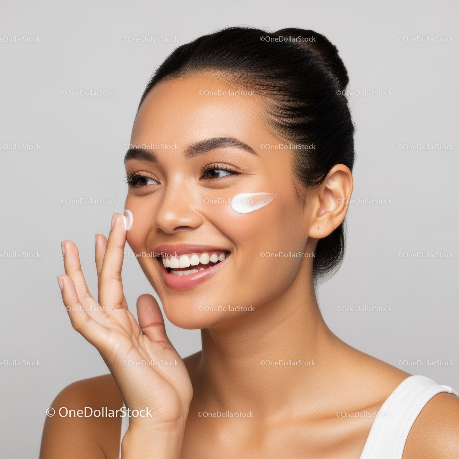 Woman Applying Facial Cream for Skincare Routine in Bright Studio