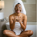 Smiling Woman with Facial Mask Relaxing in Bathroom Holding Coffee