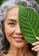 Smiling Senior Woman with Water Droplet Covered Green Leaf