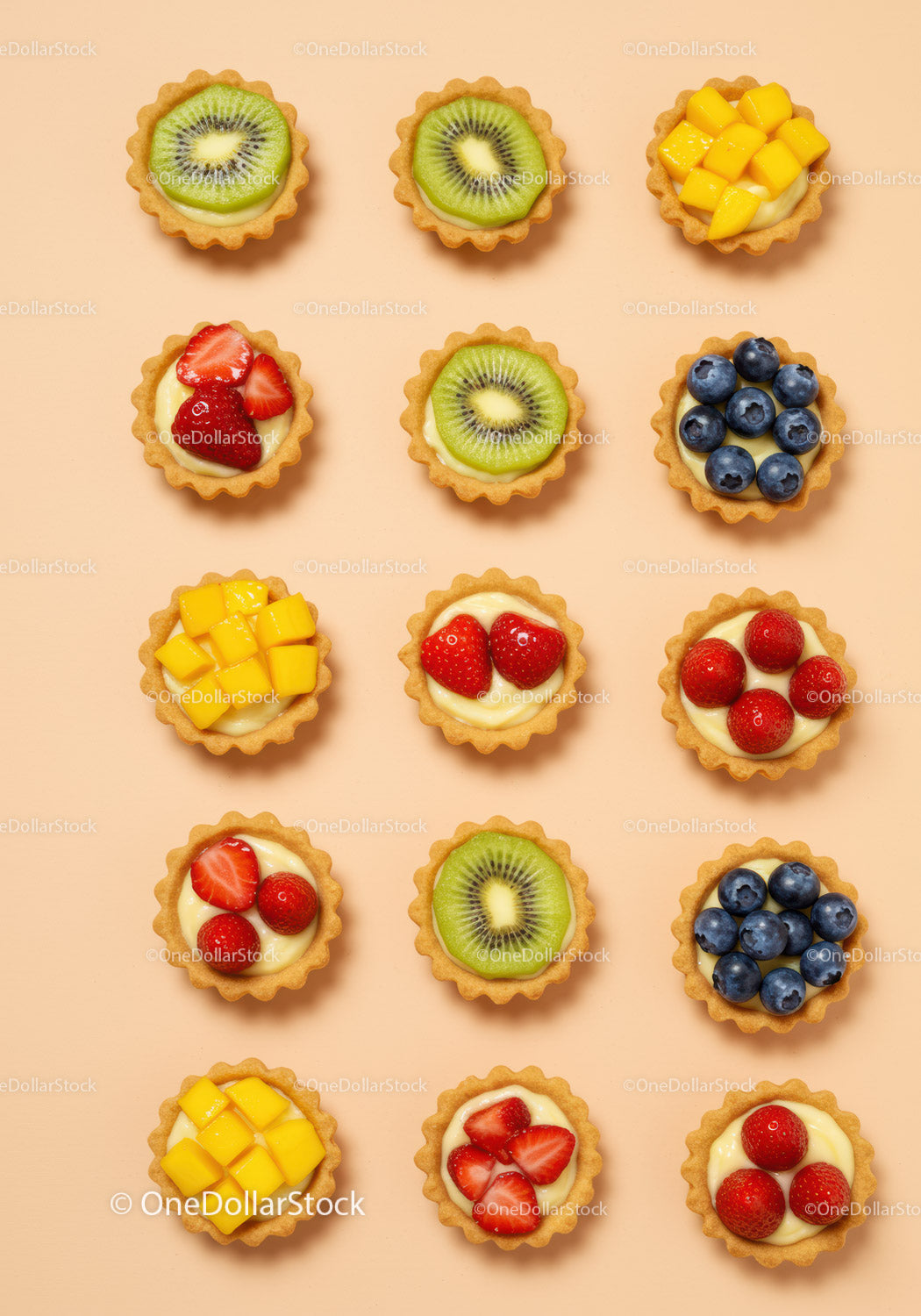 Colorful Mini Fruit Tarts Arranged on Peach Background