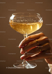 Hand holding champagne glass with sparkling bubbles