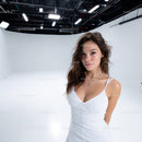 Young Woman in White Dress in Studio with Bright Lighting