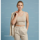 Elegant Woman in Beige Crop Top and Pants on Pastel Background