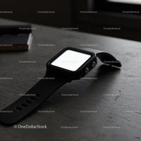 Modern black smartwatch resting on dark textured surface
