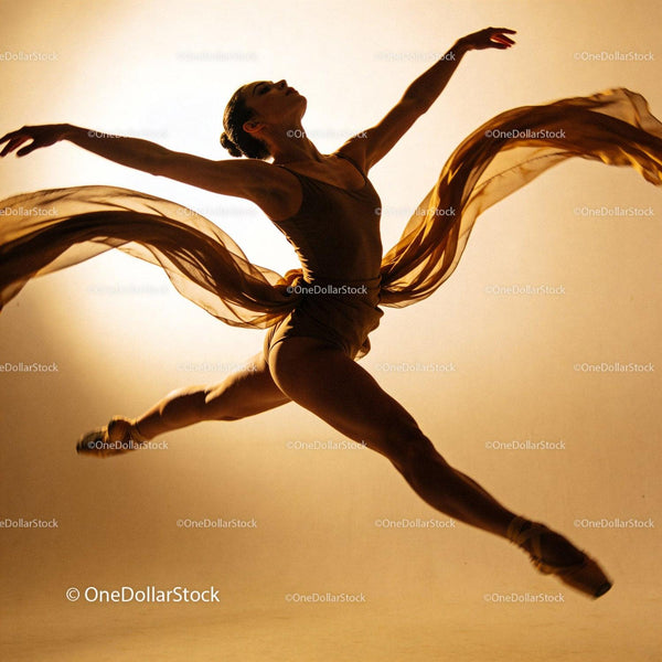 Graceful ballet dancer leaping with flowing fabric