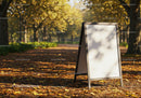 Empty sidewalk signboard in autumn park alley