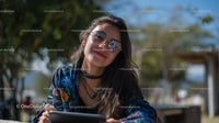 Smiling Woman with Sunglasses Enjoying Outdoors on Sunny Day