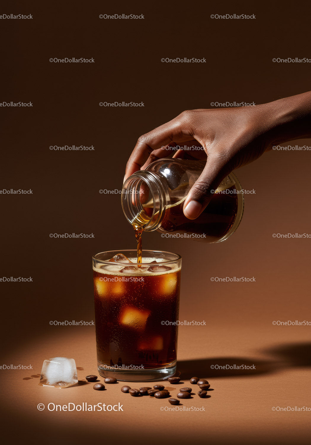 Hand pouring cold brew coffee into glass with ice cubes
